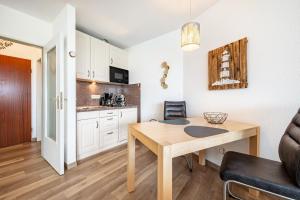 a kitchen and dining room with a table in a room at Apartementhaus Lord Nelson in Cuxhaven