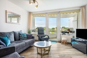 a living room with a couch and a table at Apartementhaus Lord Nelson in Cuxhaven