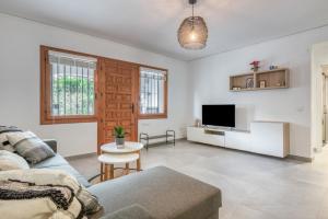 a living room with a couch and a tv at Casa Julieta in Benitachell