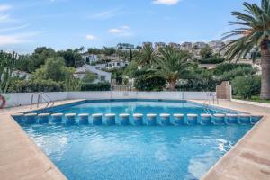 a swimming pool in a villa with palm trees at Casa Julieta in Benitachell