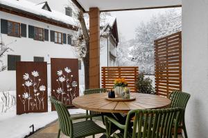 a table and chairs on a patio in the snow at Ferienwohnung Vilstalstüble in Pfronten