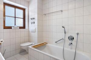 a white bathroom with a tub and a toilet at Ferienwohnung Vilstalstüble in Pfronten +36 photos