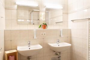 a bathroom with two sinks and a mirror at Ferienwohnungen Krapfenalm in Wagrain