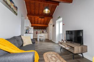 a living room with a couch and a flat screen tv at Oásis Fonte Grande in Santo António
