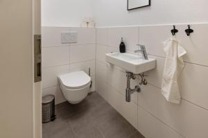 a white bathroom with a toilet and a sink at Omas Obstkiste in Stockach +17 photos
