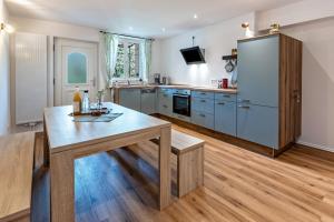 a kitchen with a wooden table and a refrigerator at Omas Obstkiste in Stockach