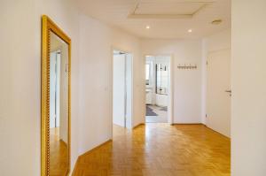 a hallway with a mirror and white walls at Ferienwohnung an der Ohme in Warburg +29 photos