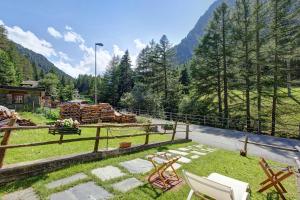 a yard with chairs and a fence and trees at Lo Peiglo Valgrisenche in Valgrisenche +14 photos