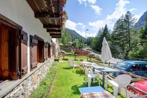 a patio with tables and chairs next to a building at Lo Peiglo Valgrisenche in Valgrisenche