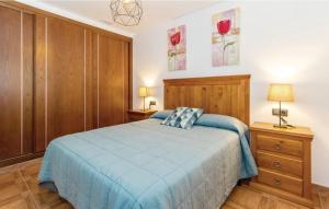 a bedroom with a blue bed and wooden cabinets at Casa Olivia in Cómpeta +19 photos