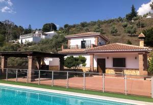 a villa with a swimming pool and a house at Casa Olivia in Cómpeta