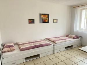 two beds in a room with white walls at Ferienwohnung Starnberg in Starnberg