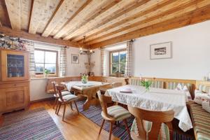 a dining room with wooden ceilings and tables and chairs at Ferienwohnungen Zwick Spinei in Malles Venosta