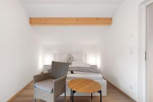 ein Schlafzimmer mit einem Bett, einem Tisch und einem Stuhl in der Unterkunft Talferblick Stern in Sarntal