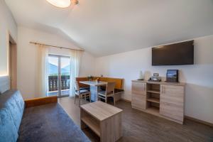 a living room with a couch and a table with a television at Gartenheim App Elisabeth in Schenna
