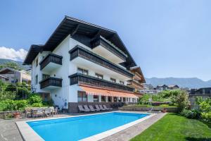 an apartment with a swimming pool and a building at Gartenheim App Elisabeth in Schenna