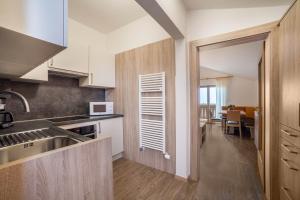 a kitchen with white appliances and a dining room at Gartenheim App Elisabeth in Schenna