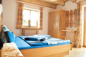 a bedroom with a bed with blue sheets and a window at Ferienwohnungen Krapfenalm in Wagrain