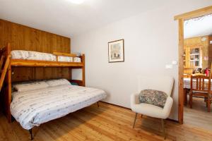 a bedroom with a bunk bed and a chair at Appartamenti Pila Vacanze 2 in Gressan