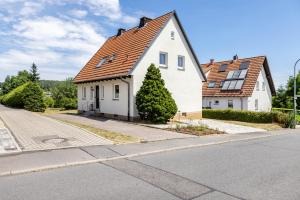 a white house with a red roof on a street at Ferienhaus Barockhaus Fulda in Petersberg