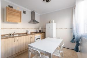 a kitchen with a table and a white refrigerator at Apartamento Turquesa Nerja in Nerja