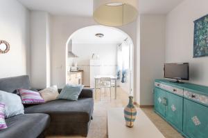 a living room with a couch and a tv at Apartamento Turquesa Nerja in Nerja