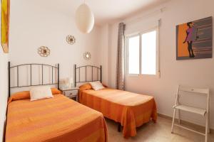 a bedroom with two beds and a window at Apartamento Turquesa Nerja in Nerja