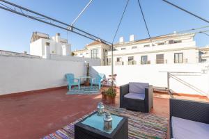 a patio with chairs and tables on a roof at Apartamento Turquesa Nerja in Nerja