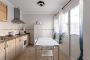 a kitchen with a table and chairs in a room at Apartamento Turquesa Nerja in Nerja +12 photos