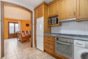 a kitchen with a white refrigerator and a stove at Xisqueta in Campo