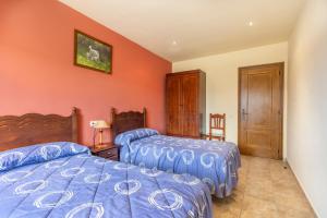 two beds in a bedroom with orange walls at Xisqueta in Campo