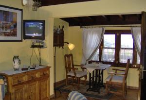 a living room with a table and a television at Aptos Monasterio de San Antonio 4 in Icod de los Vinos