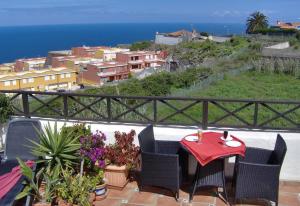 a table and chairs on a balcony with a view of the ocean at Aptos Monasterio de San Antonio 4 in Icod de los Vinos +24 photos