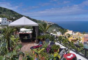 a patio with a white umbrella and the ocean at Aptos Monasterio de San Antonio 4 in Icod de los Vinos
