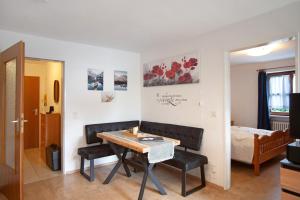 a living room with a dining room table and a bed at Ferienwohnung Reindler in Fischen
