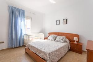a bedroom with a bed and a crib and a window at Planta uno Valle de Abdalajis in Valle de Abdalagís