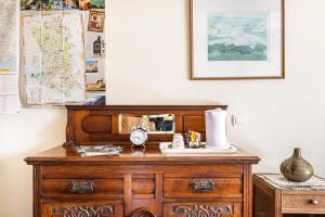 a wooden dresser with a clock on top of it at Bourdeverre Chambres D'hôtes in Sanxay