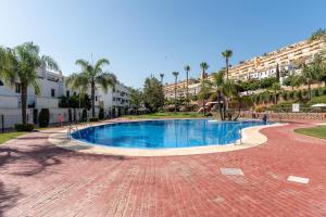 a swimming pool in a resort with palm trees and buildings at 206 Navigolf 3 in La Cala de Mijas