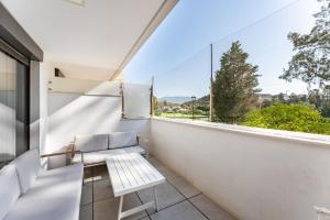 a white balcony with a bench and a window at 206 Navigolf 3 in La Cala de Mijas