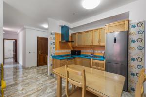 a kitchen with a wooden table and a stainless steel refrigerator at Lujan 3c Entre Cielo Y Mar in Puntallana