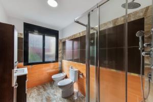a bathroom with a toilet and a glass shower at Lujan 3c Entre Cielo Y Mar in Puntallana +12 photos