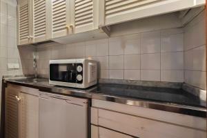a microwave sitting on top of a kitchen counter at Navila Pasillo Superior in Ibiza Town +16 photos