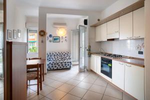a kitchen with white cabinets and a table and a dining room at Mirafiori in Alassio