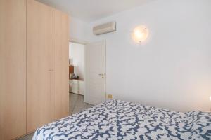 a bedroom with a bed with a blue and white blanket at Mirafiori in Alassio