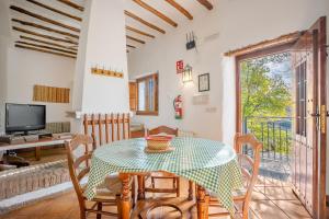 a dining room with a table and chairs and a television at Apartamento El Tinao in La Zubia