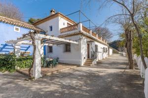 a white house with a pergola and a table at Apartamento El Tinao in La Zubia