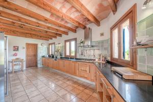 a large kitchen with wooden ceilings and wooden counters at Casa Verde in Sa Pobla