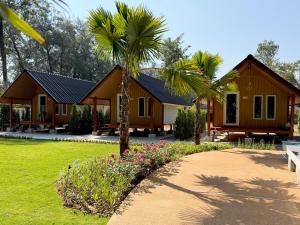 a house with palm trees in front of it at Ther lay beach resort in Sikao