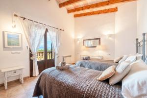 two beds in a room with a window at Casa Verde in Sa Pobla +20 photos