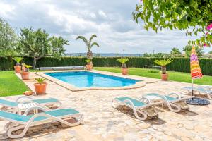 a swimming pool with lounge chairs and an umbrella at Casa Verde in Sa Pobla